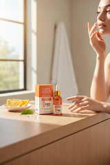 Super White Natural Vitamin C serum bottle and box on a wooden table with orange slices, beside a woman's profile.